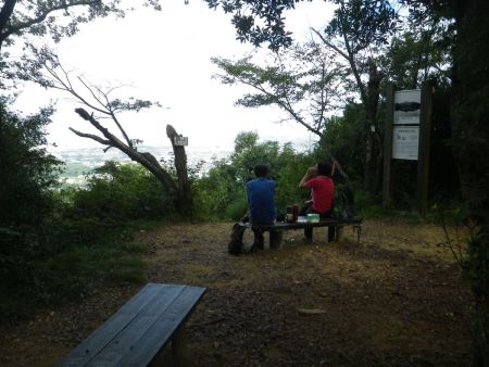 雨山の山頂看板があるのは小屋の裏側なんだけど、ここにも人がいた。空いてるベンチに座って休憩した